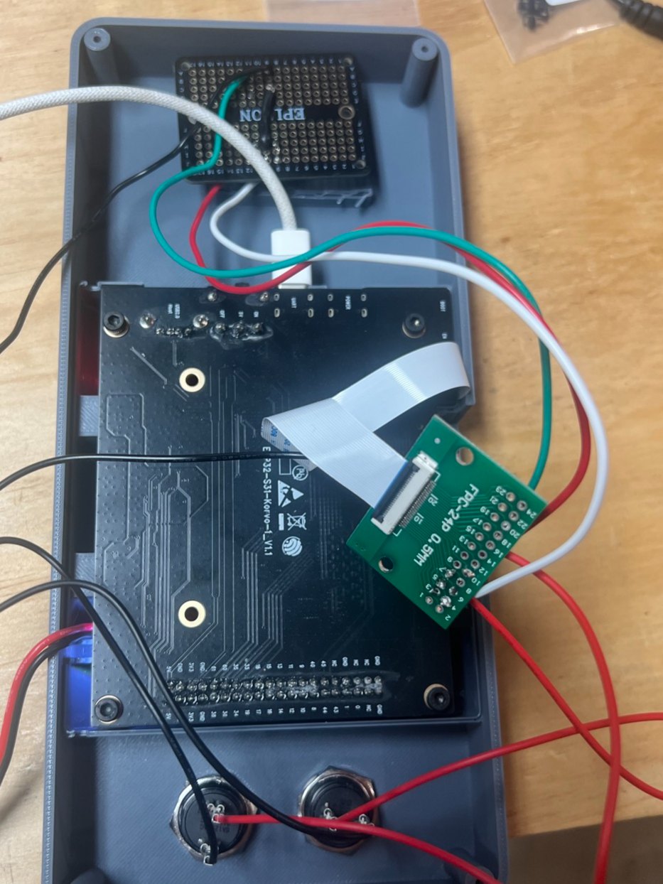 Inside the open case: the circuit board face down, a ribbon cable running to a small green adapter board, and wires leading to two buttons